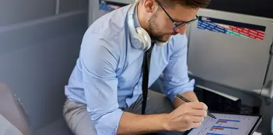 Person writing on a tablet with a stylus at a desk